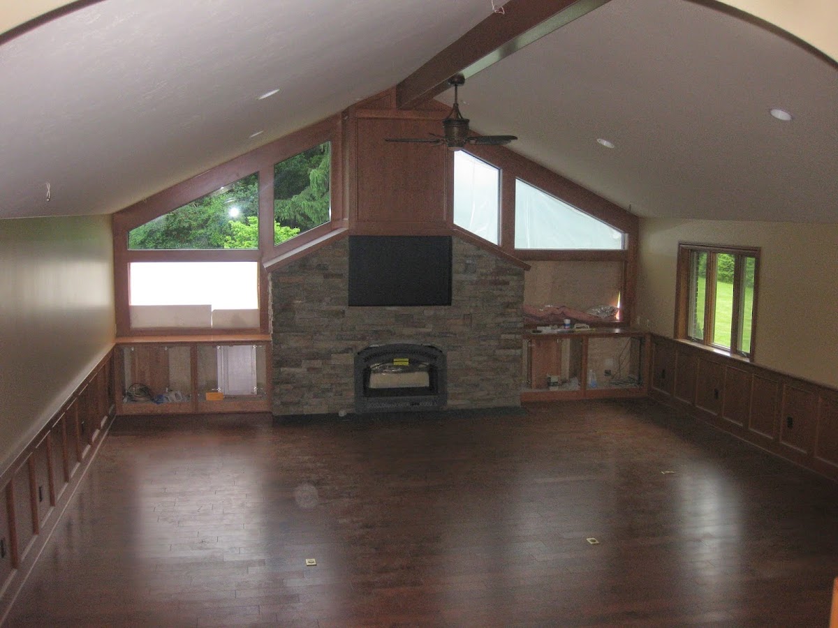 A living room mid-renovation with a stone fireplace, ready for repainting